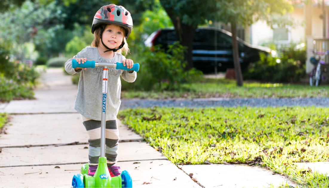 Little boy peering around the corner of the inside of a bright yellow playground slide